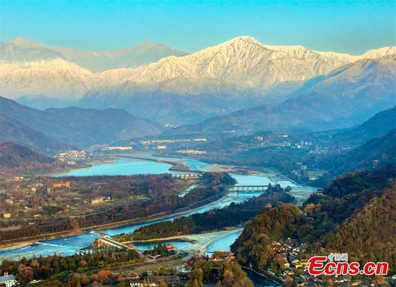 Photo prise le 29 décembre 2021 montrant le système d'irrigation de Dujiangyan au pied d'une montagne enneigée, dans la partie ouest de la plaine de Chengdu, dans la province du Sichuan (sud-ouest de la Chine). (Chen Xianlin/China News Service)