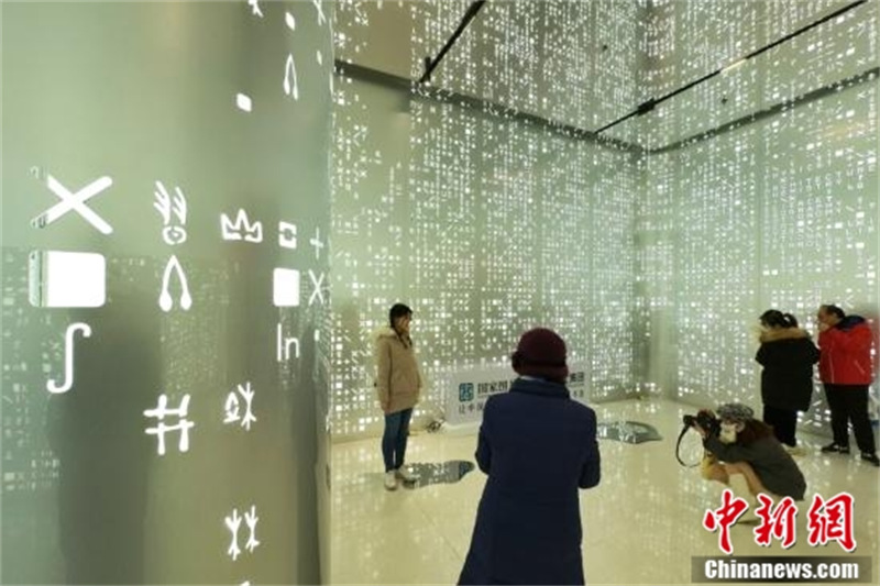 Des visiteurs découvrent l'évolution de l'écriture dans une exposition d'écriture ossécaille à Tianjin