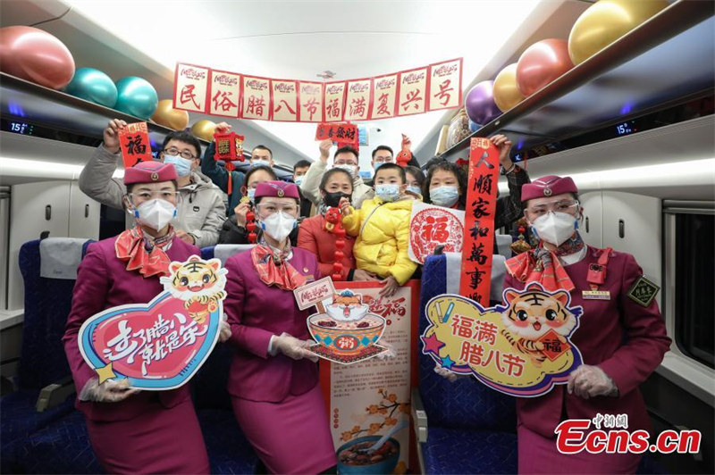 Des passagers et des hôtesses de bord du train Fuxing EMU C5980 prennent une photo de groupe, à Bijie, dans la province du Guizhou (sud-ouest de la Chine), le 9 janvier 2022. (Qu Honglun/China News Service)