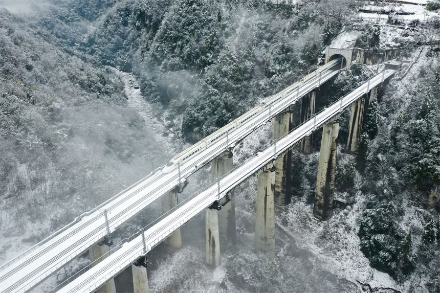 Hubei : des trains transportent des passagers le long des monts Wuling enveloppés de neige