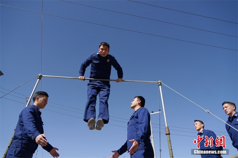 Des membres de la brigade de pompiers participent à un entraînement sur des rouleaux de barre horizontale dans le comté de Zhiduo de la préfecture autonome tibétaine de Yushu, dans la province du Qinghai (nord-ouest de la Chine), le 23 mars. (Ma Mingyan / China News Service)