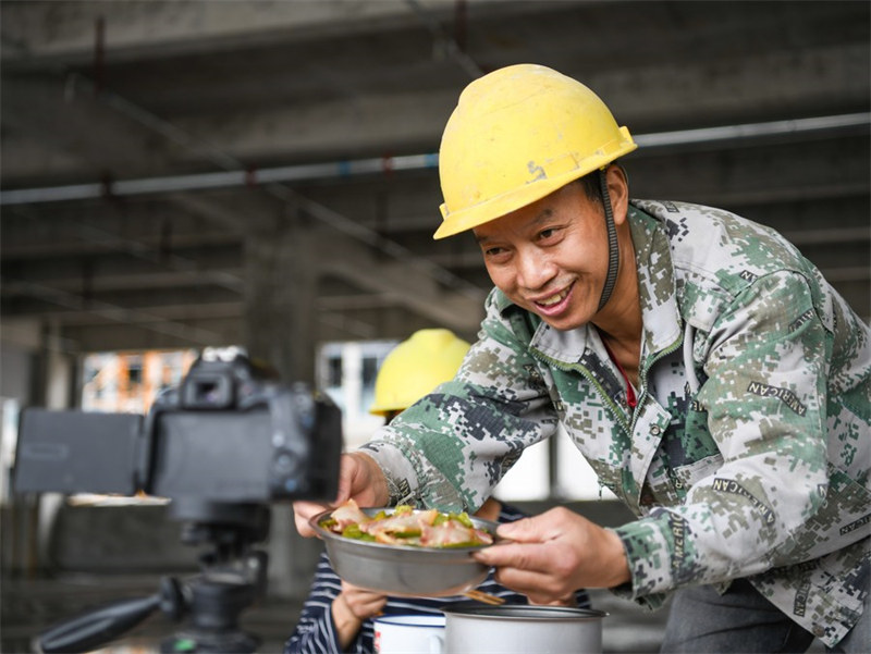 He Chuan montre à ses abonnés ses plats pendant la pause déjeuner dans un blog vidéo enregistré sur un chantier de construction à Dazhou, dans la province du Sichuan, dans le sud-ouest de la Chine, le 29 avril 2022. (Xinhua / Wang Xi)