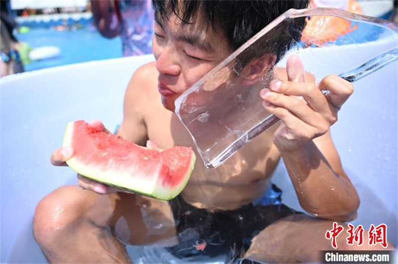 Des habitants de Chongqing mangent des pastèques assis dans des seaux de glace