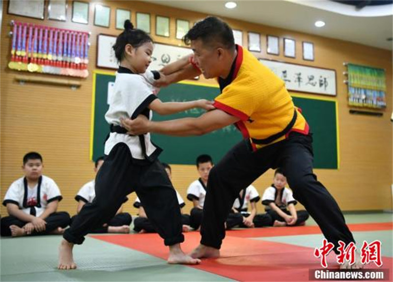 Yang Xing (à droite), héritier de la « lutte de Kung-Fu », enseigne les mouvements de lutte aux étudiants dans un gymnase à Shijiazhuang, capitale de la province du Hebei (nord de la Chine), le 3 août. (Zhai Siyu / China News Service)