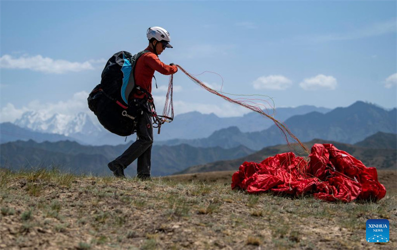 Un amateur de parapente cherche à découvrir davantage la beauté du Xinjiang depuis le ciel