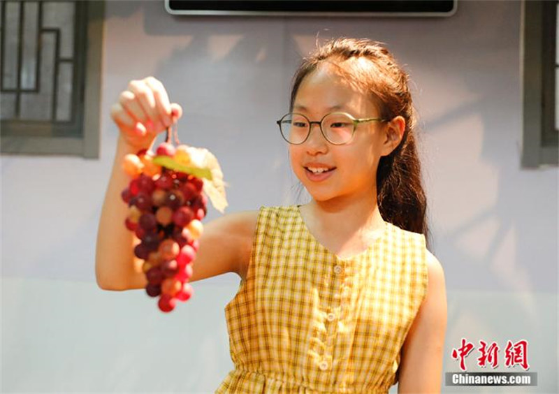 Une fillette chinoise âgée de 10 ans hérite du métier traditionnel de fabrication de raisins en verre