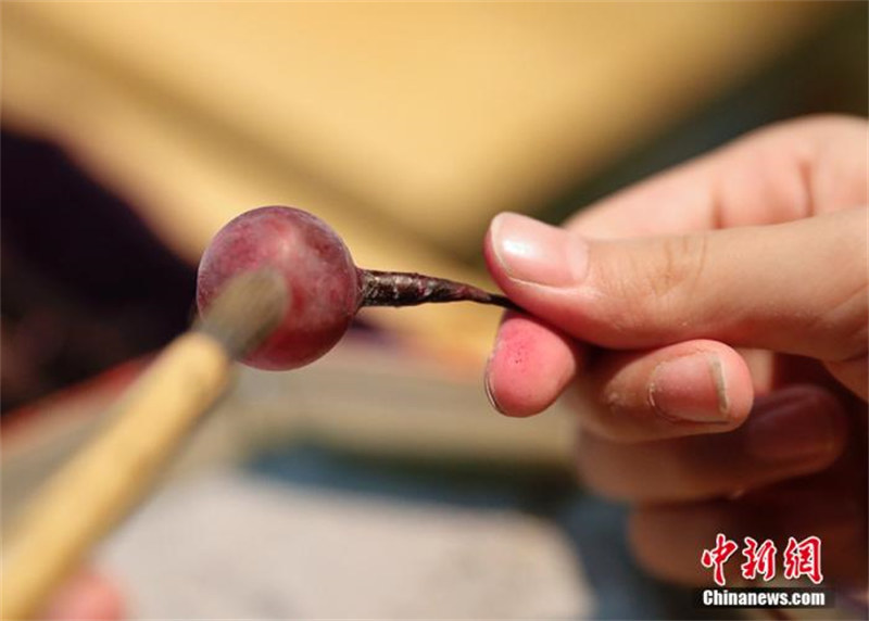 Une fillette chinoise âgée de 10 ans hérite du métier traditionnel de fabrication de raisins en verre