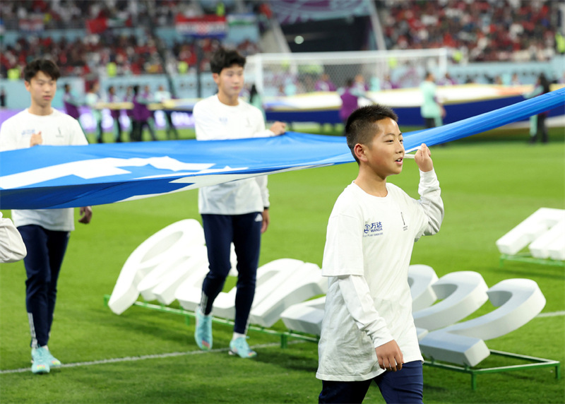 Jin Cancan (premier rang) apparaît en tant qu'un des porteurs du drapeau de la FIFA avant le match pour la troisième place entre la Croatie et le Maroc de la Coupe du Monde de la FIFA au Stade international Khalifa, à Doha, au Qatar, le 17 décembre 2022. (Photo / Xinhua)