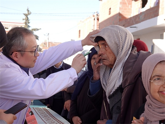 Hu Changrong, membre de l'équipe médicale chinoise en Tunisie, inspecte les yeux d'un vieil homme lors d'une activité clinique gratuite dans la province du Kef, dans le nord-ouest de la Tunisie, le 19 février 2023. (Photo / Xinhua)