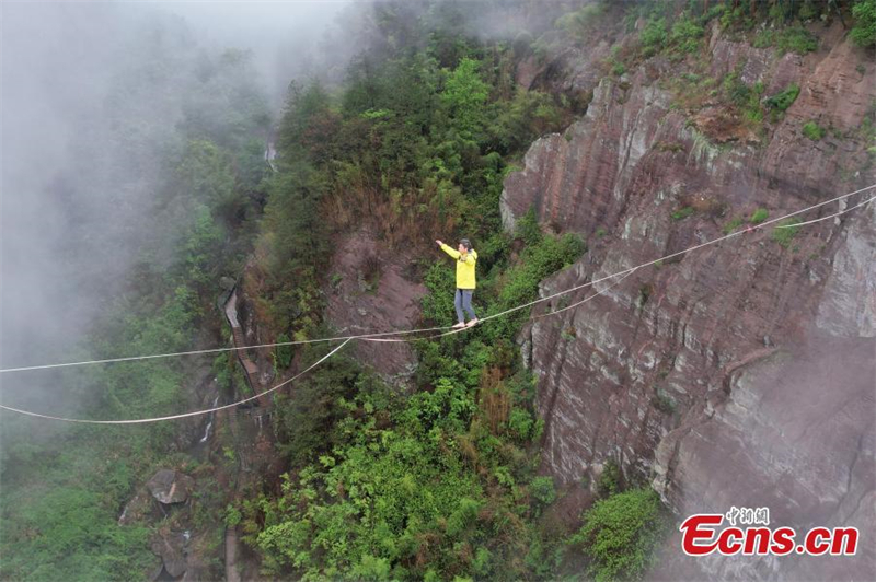 Photo prise le 24 avril montrant un funambule traversant une vallée de 300 mètres de long dans le parc géologique national de Shiniuzhai du comté de Pingjiang, dans la province du Hunan (centre de la Chine).  (Yang Huafeng / China News Service)