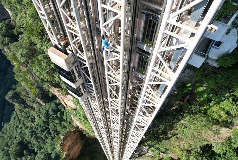 L'« homme-araignée » français escalade à mains nues le derrick en acier de 172 mètres de l'ascenseur extérieur le plus haut du monde, dans la zone touristique de Wulingyuan à Zhangjiajie, dans la province du Hunan (centre de la Chine), le 28 juin 2023. (Wu Yongbing / China News Service)