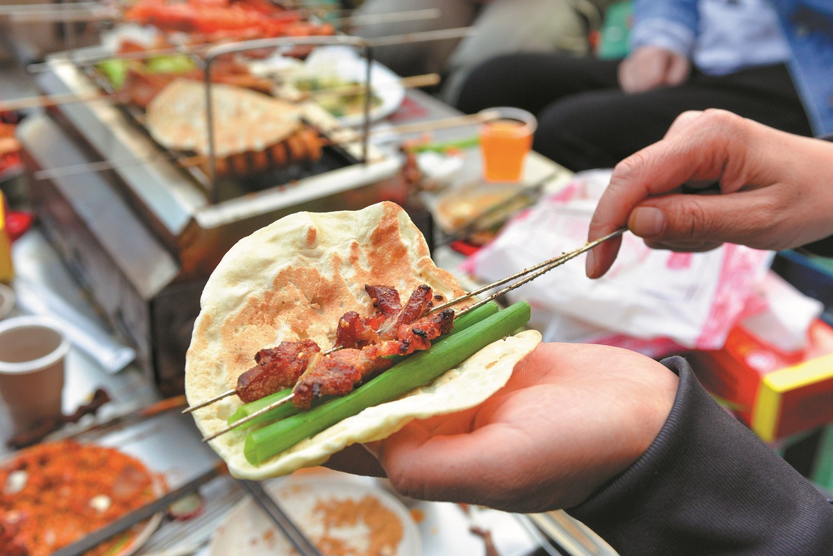 Un client montre comment manger un barbecue, le 31 mars à Zibo, dans la province du Shandong (est de la Chine). (Photo / China Daily)