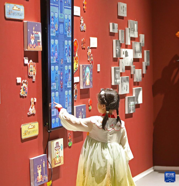 Un enfant admire des œuvres d'art de la deuxième Exposition de l'Art numérique, à Shenyang, capitale de la province du Liaoning (nord-est de la Chine), le 8 juillet. (Photo/Xinhua)