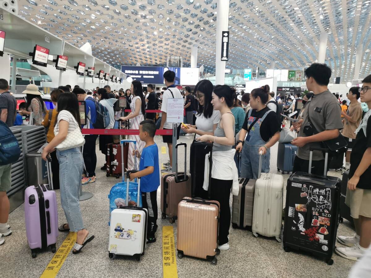 Le 9 juillet, des passagers font la queue au comptoir d'enregistrement de l'aéroport international Bao'an de Shenzhen. (Wang Dongyuan / China News Service)