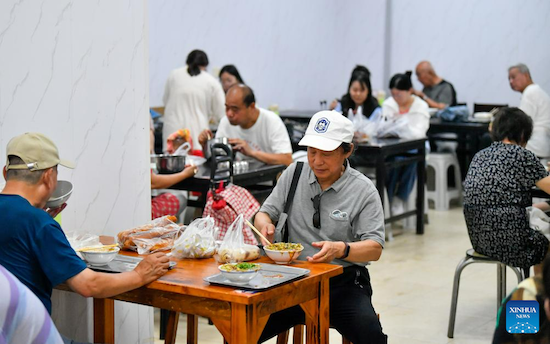 Des personnes prennent leur petit-déjeuner dans un restaurant au Coin nord-ouest de la ville de Tianjin située dans le nord de la Chine. Le Coin nord-ouest doit son nom à sa situation dans le nord-ouest de la vieille ville de Tianjin. Le matin, de nombreux touristes parlant différents dialectes y traînent leurs valises pour prendre un petit-déjeuner aux couleurs locales. (Xinhua/Sun Fanyue)