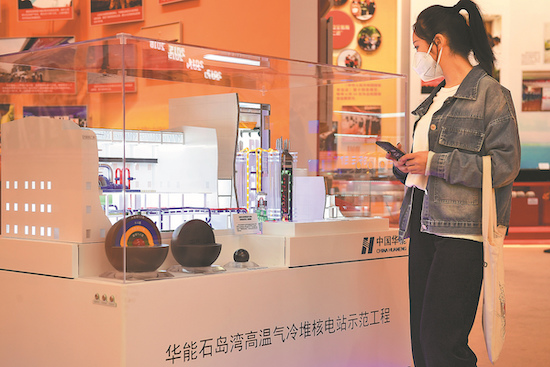 Un visiteur regarde une maquette du projet nucléaire de Shidaowan lors d'une exposition à Beijing. (Tian Yuhao / China News Service)