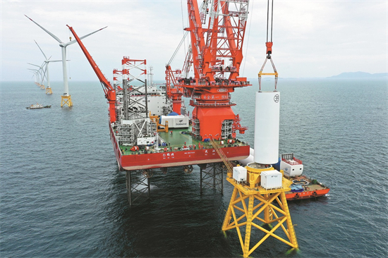 Le développement de l'énergie éolienne offshore sera bénéfique pour les zones côtières. L'installation de la tour d'une éolienne dans le parc éolien offshore de Baihetan. (Photo/Xinhua)