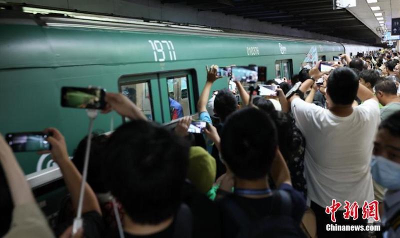 Des passagers prennent des photos d'une rame de métro de la ligne 1 du métro de Beijing, sur le thème des années 1960. (Yang Kejia / China News Service)