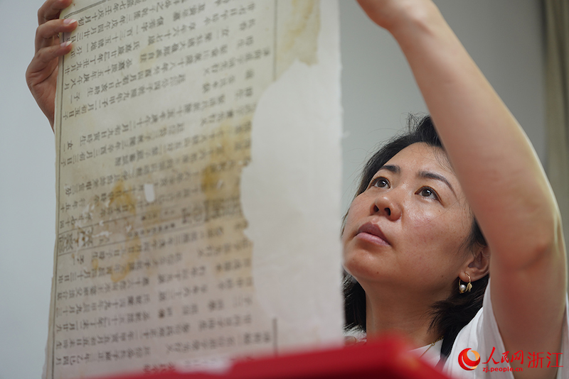 Un restaurateur de reliques culturelles inspecte une page d'un livre ancien au Pavillon Tianyi, à Ningbo, dans la province du Zhejiang (est de la Chine). (Zhang Yongtao / Le Quotidien du Peuple en ligne)