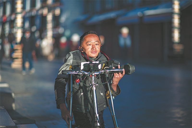 Lorsqu'il en a l'occasion, Lhakpa Dondrub prend des photos d'animaux et de passants le long du célèbre bazar du Barkhor à Lhassa. (Jiang Fan / Xinhua)