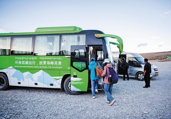 Les visiteurs montent à bord d'une nouvelle navette énergétique sur le parking d'une zone touristique de la région autonome du Tibet (sud-ouest de la Chine). (Sun Fei / Xinhua)