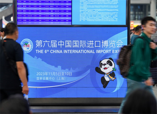 Des gens passent devant un panneau d'affichage électronique pour la sixième Exposition internationale d'importation de la Chine (CIIE), à la Gare de Hongqiao à Shanghai, dans l'est de la Chine, le 3 novembre 2023. (Xinhua/Ding Ting)