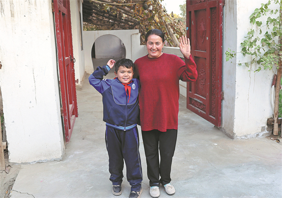 Abdulwal Abdula, 9 ans, lève le bras droit pour dire au revoir aux invités quittant sa maison dans un village du comté de Hotan, dans la région autonome ouïgoure du Xinjiang (nord-ouest de la Chine), le 26 octobre. (Fong Yongbin / China Daily)