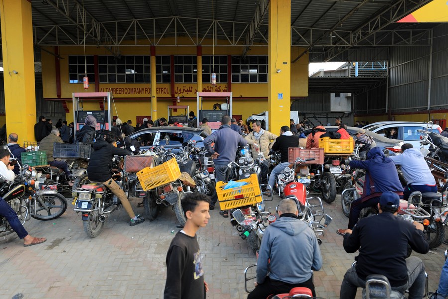 Des gens attendent dans une station de ravitaillement en carburant dans la ville de Khan Younis, dans le sud de la bande de Gaza, le 28 novembre 2023. (Xinhua/Yasser Qudih)