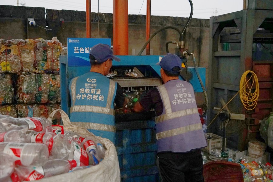 Des ouvriers compressent des bouteilles en plastique triées dans une « Petite Maison Bleue » du district de Jiaojiang de la ville de Taizhou, dans la province chinoise du Zhejiang (est de la Chine), le 17 octobre 2023. (Lin Guangyao / Xinhua)