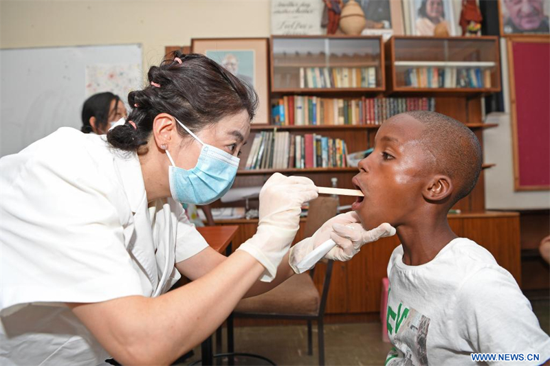 Une membre de l'équipe médicale chinoise examine la cavité buccale d'un enfant dans un Village d'enfant SOS à Windhoek, en Namibie, le 11 décembre 2023. (Xinhua/Ndalimpinga Iita)