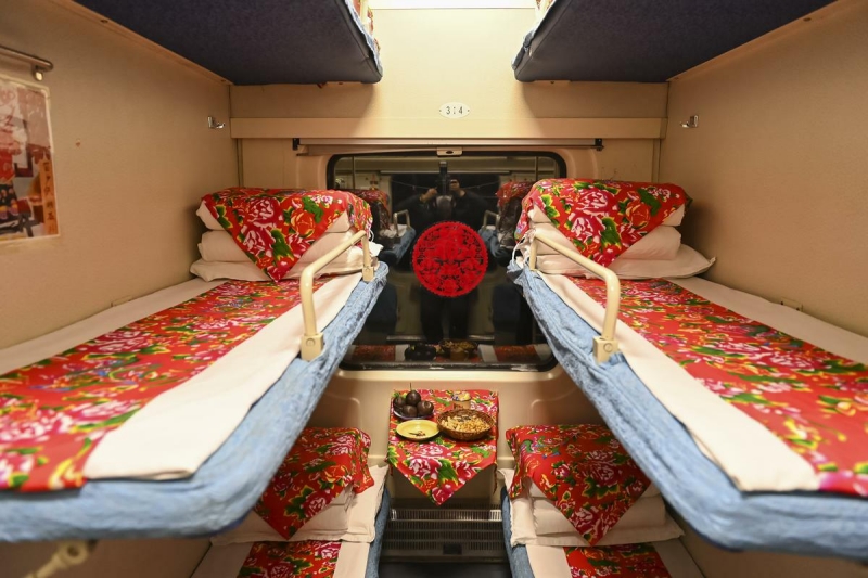 Une voiture-lit sur le thème de la culture folklorique du Nord-Est de la Chine est décorée d'éléments folkloriques du Nord-Est, tels que des papiers découpés sur les fenêtres et des draps de lit colorés. (Photo / Pic.people.com.cn)
