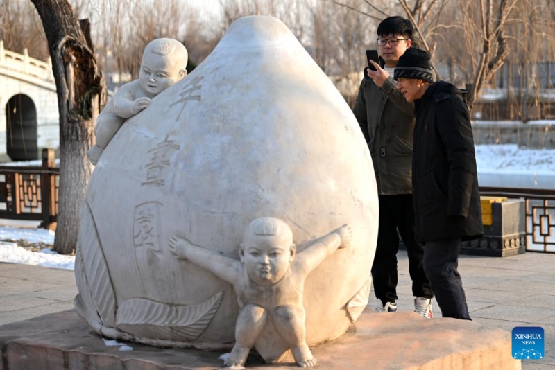 Xi Wang (à gauche) et son mentor Wang Wenda visitent un parc sur le thème des images du Nouvel An à Tianjin (nord de la Chine), le 27 décembre 2023.