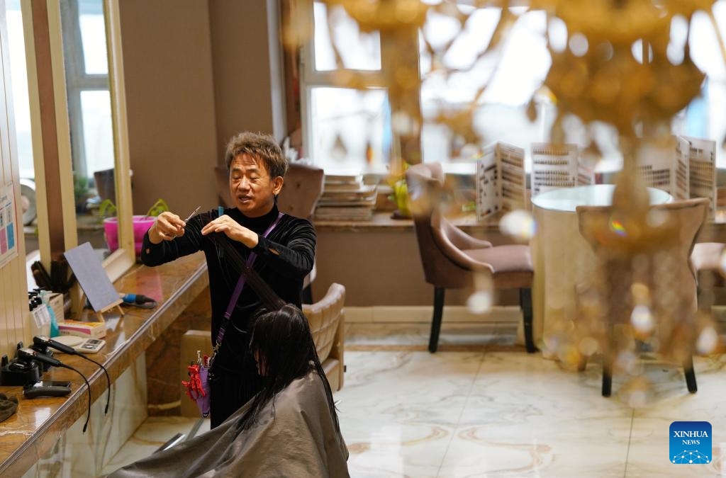 An Jong-euk, un coiffeur originaire de la République de Corée, sert un client à Urumqi, capitale de la région autonome ouïgoure du Xinjiang (nord-ouest de la Chine), le 8 janvier 2024. (Aman / Xinhua)