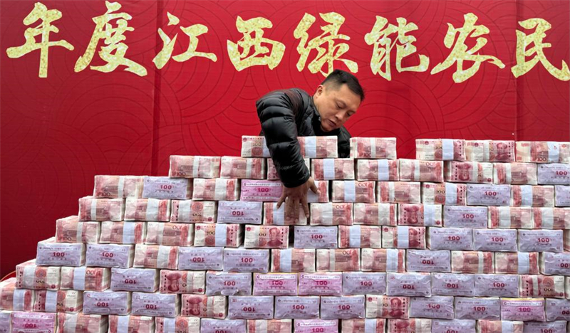 Des sommes d'argent totalisant plus de 11 millions de yuans sont soigneusement disposées comme prime de fin d'année pour les agriculteurs du canton de Dinghu, dans le comté d'Anyi de la province du Jiangxi (est de la Chine), le 8 janvier 2024. (Photo / Xinhua)
