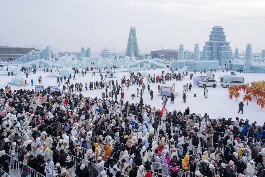 Des touristes font la queue pour glisser sur un toboggan de glace au Monde de glace et de neige de Harbin. (Photo / Xinhua)