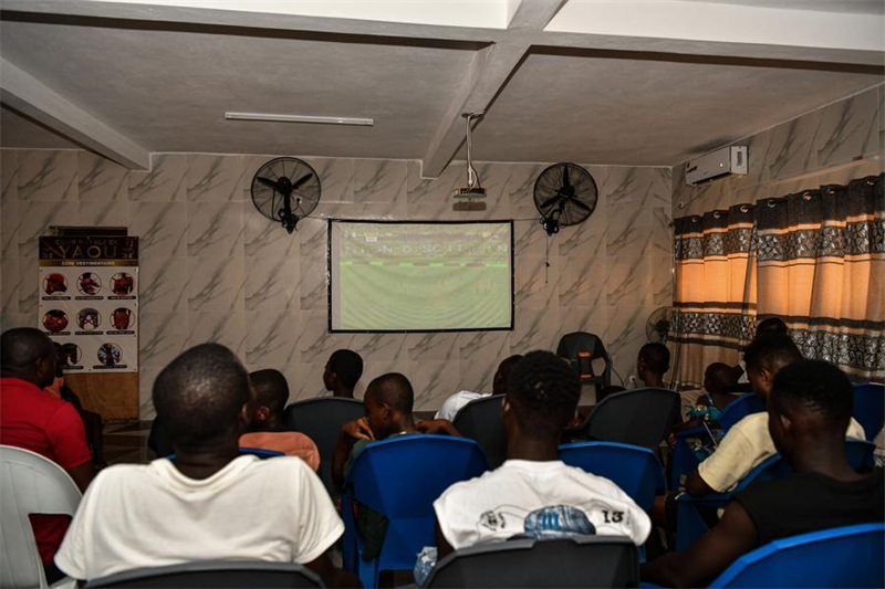 Des gens regardent les matches de la CAN 2023 grâce au projet de télévision par satellite chinois dans le village de Yaou, en Côte d'Ivoire, le 14 janvier 2024. (Han Xu / Xinhua)