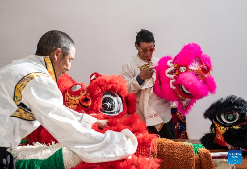 Tengpa Anye (à droite) nettoie un accessoire de danse du lion dans une école primaire de la ville de Xobando du comté de Lhorong, à Qamdo, dans la région autonome du Xizang (sud-ouest de la Chine), le 19 janvier 2024. (Sun Fei / Xinhua)