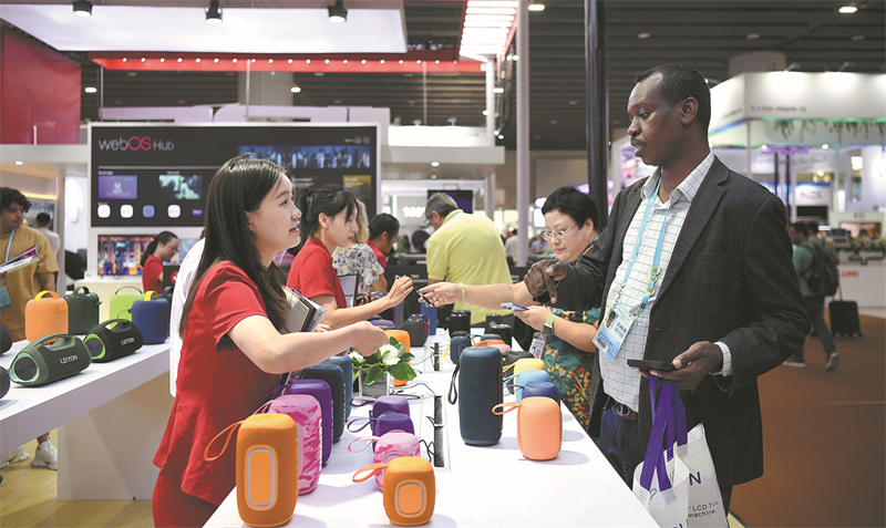 Une employée (à gauche) répond aux questions des visiteurs lors d'une foire commerciale à Guangzhou. (Deng Hua / Xinhua)