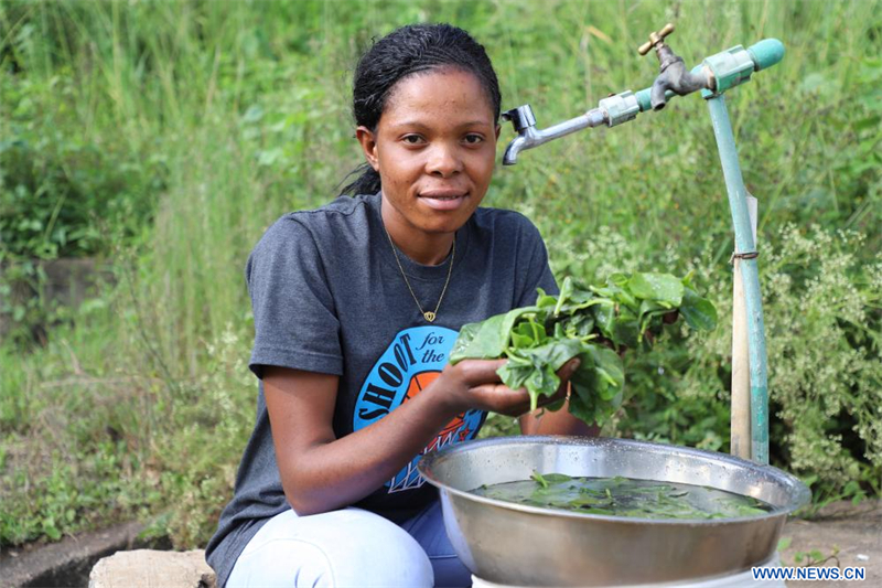 Une habitante lave des légumes avec l'eau fournie par le nouveau projet de système d'approvisionnement en eau d'Arusha bâti par la société Power Construction Corporation of China, à Arusha, en Tanzanie, le 28 janvier 2024. (Hua Hongli / Xinhua)