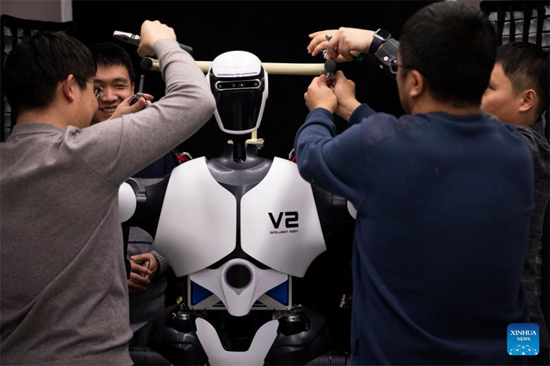 Des chercheurs ajustent un robot humanoïde dans un laboratoire d'intelligence artificielle, le 31 janvier 2024. (Jin Liwang / Xinhua)