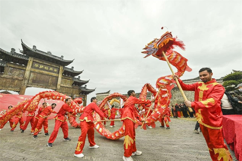 Des étudiants étrangers de l'Université de Nanchang découvrent la joie de la danse du dragon de la fête du Printemps dans le district historique et culturel de Wenchangli, à Fuzhou, dans la province du Jiangxi (sud-est de la Chine), le 13 février 2024. (Li Jie / Pic.People.com.cn)