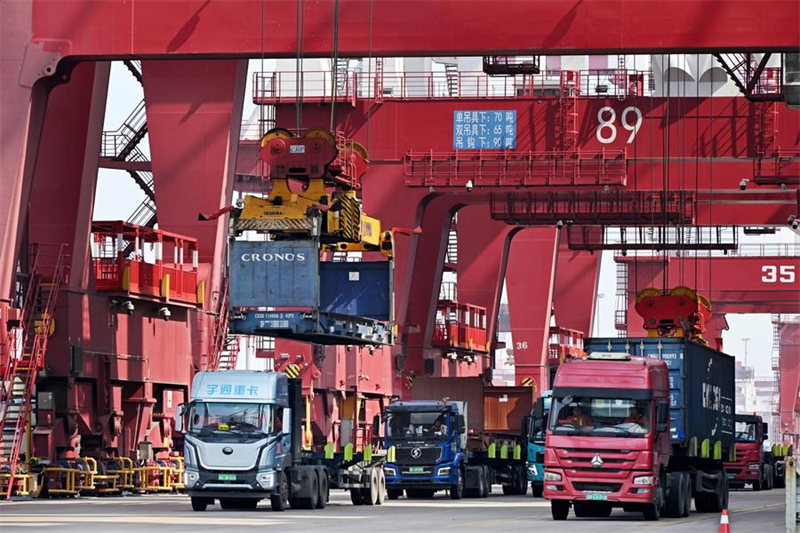 Des camions transportent des conteneurs dans le port de Qingdao, dans la province du Shandong (est), le 13 mars 2024. (Photo : Li Ziheng)