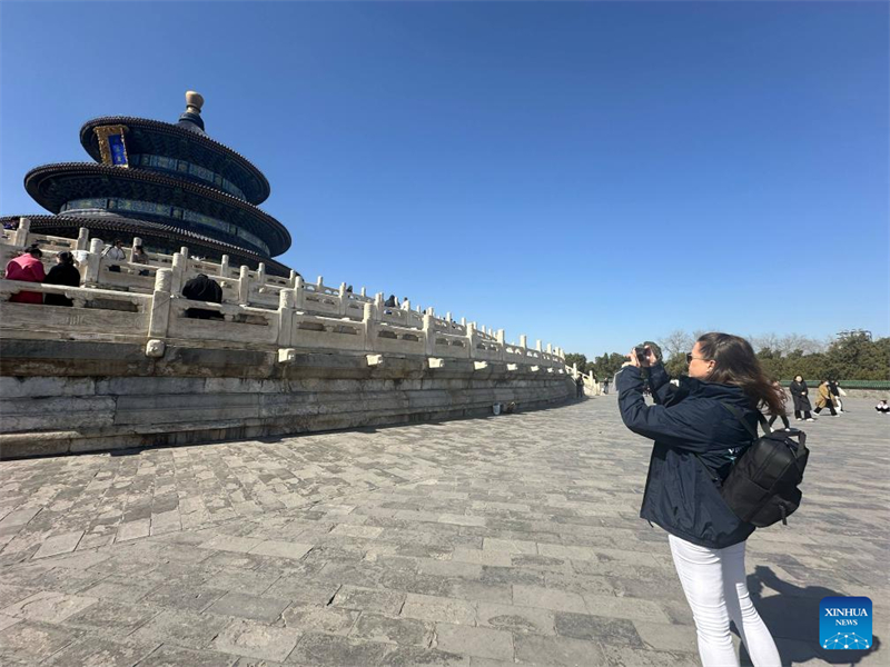 Un touriste européen prend des photos alors qu'il visite le Parc Tiantan, ou Temple du Ciel, le 20 mars 2024 à Beijing. (Yang Shujun / Xinhua)