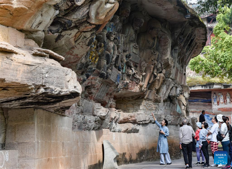 Des touristes visitent le site touristique des sculptures rupestres de Dazu à Chongqing