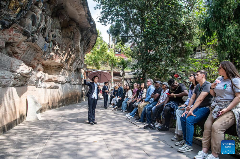 Des touristes visitent le site touristique des sculptures rupestres de Dazu à Chongqing