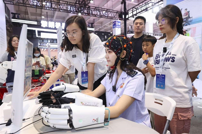 Le 21 août 2023, une jeune fille fait l'expérience de la plateforme multimodale d'interface cerveau-ordinateur d'intelligence artificielle lors de l'Exposition mondiale des robots 2023 à Beijing. (Chen Xiaogen / Pic.People.com.cn)