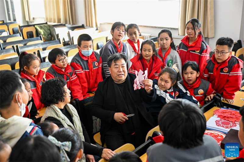Duan Jianjun (au centre) enseigne à ses élèves des techniques de découpage de papier à l'école primaire n° 2 de Horinger, dans le comté de Horinger de la région autonome de Mongolie intérieure (nord de la Chine), le 14 mars 2024. (Li Zhipeng / Xinhua)