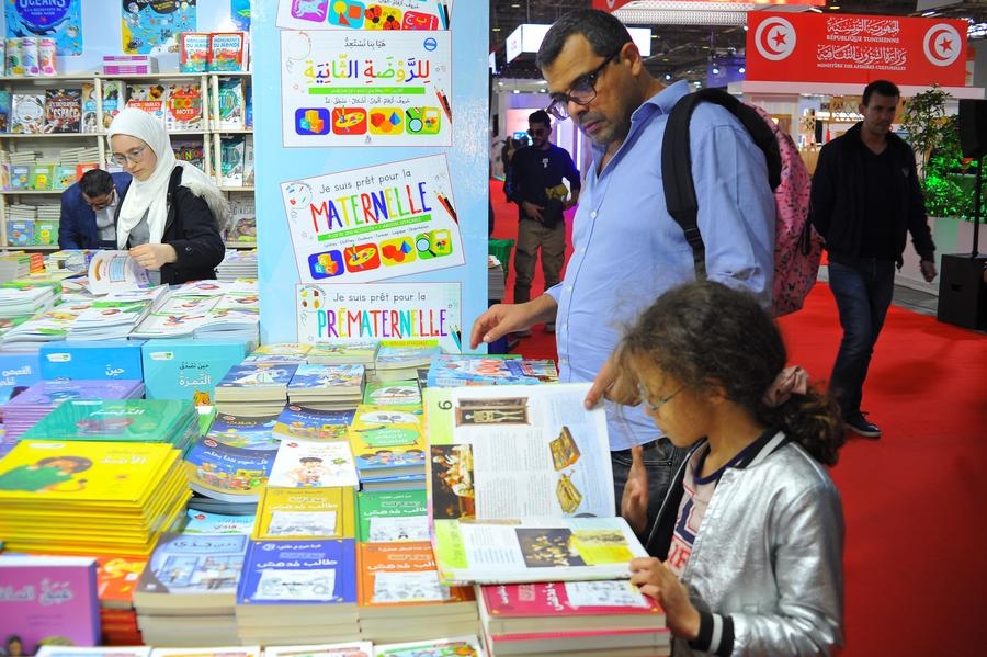 Des gens choisissent des livres à la Foire internationale du livre de Tunis, en Tunisie, le 19 avril 2024. (Xinhua/Adel Ezzine)