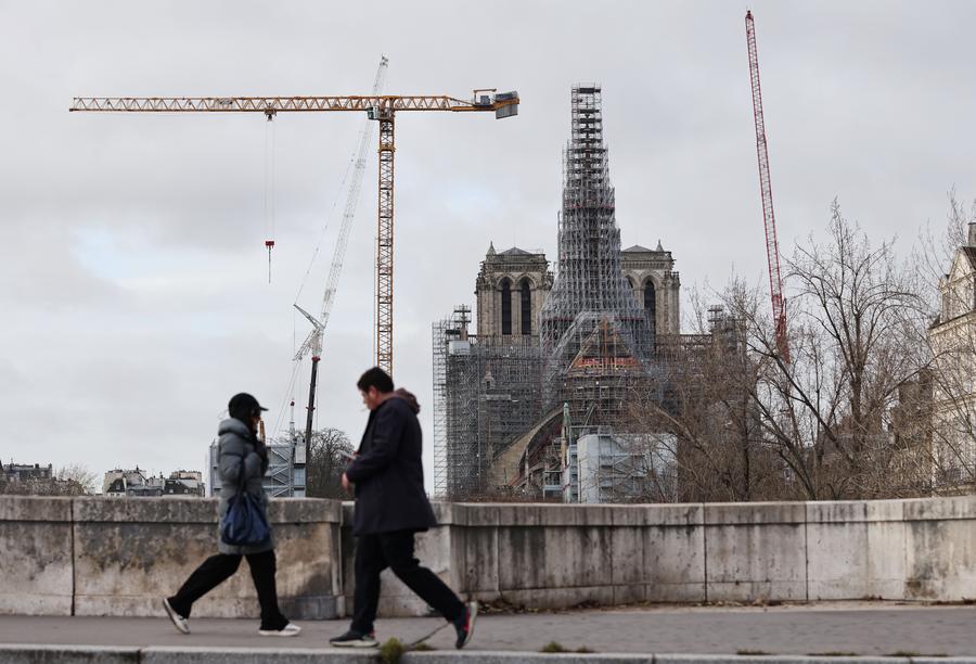 Des gens passant devant la cathédrale Notre-Dame de Paris en cours de rénovation, dans la capitale française, le 8 décembre 2023. (Photo : Gao Jing)