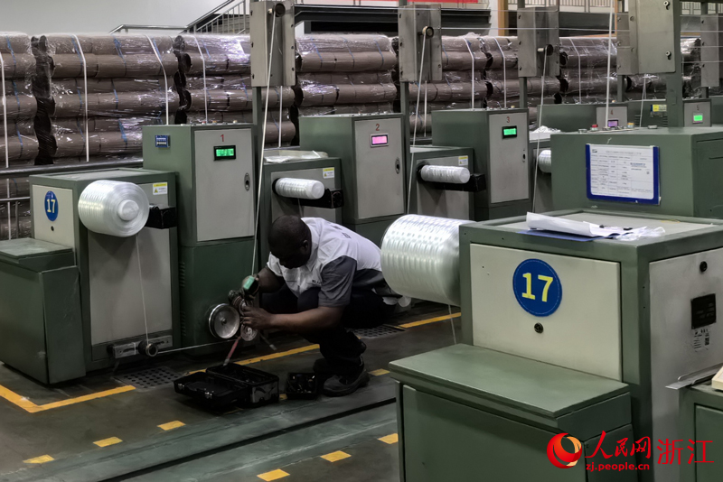 Romuald Takam Tedoum, un électricien camerounais, travaille dans un atelier du Jushi Group, un producteur chinois de fibre de verre basé à Tongxiang, dans la province du Zhejiang (est de la Chine). (Zhang Feiran / Le Quotidien du Peuple en ligne)